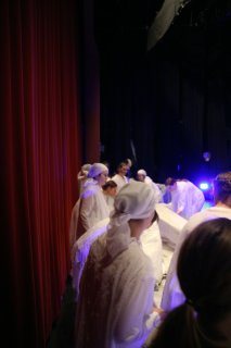 ... members of the chorus set up the next scene.